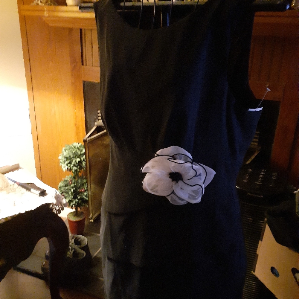 Good black dress with a white flower on it.